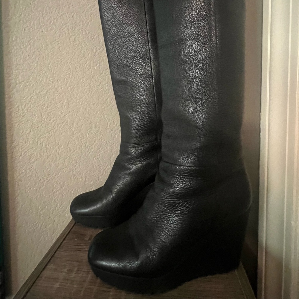 Meticulously maintained authentic Gucci knee high black leather wedge boots.